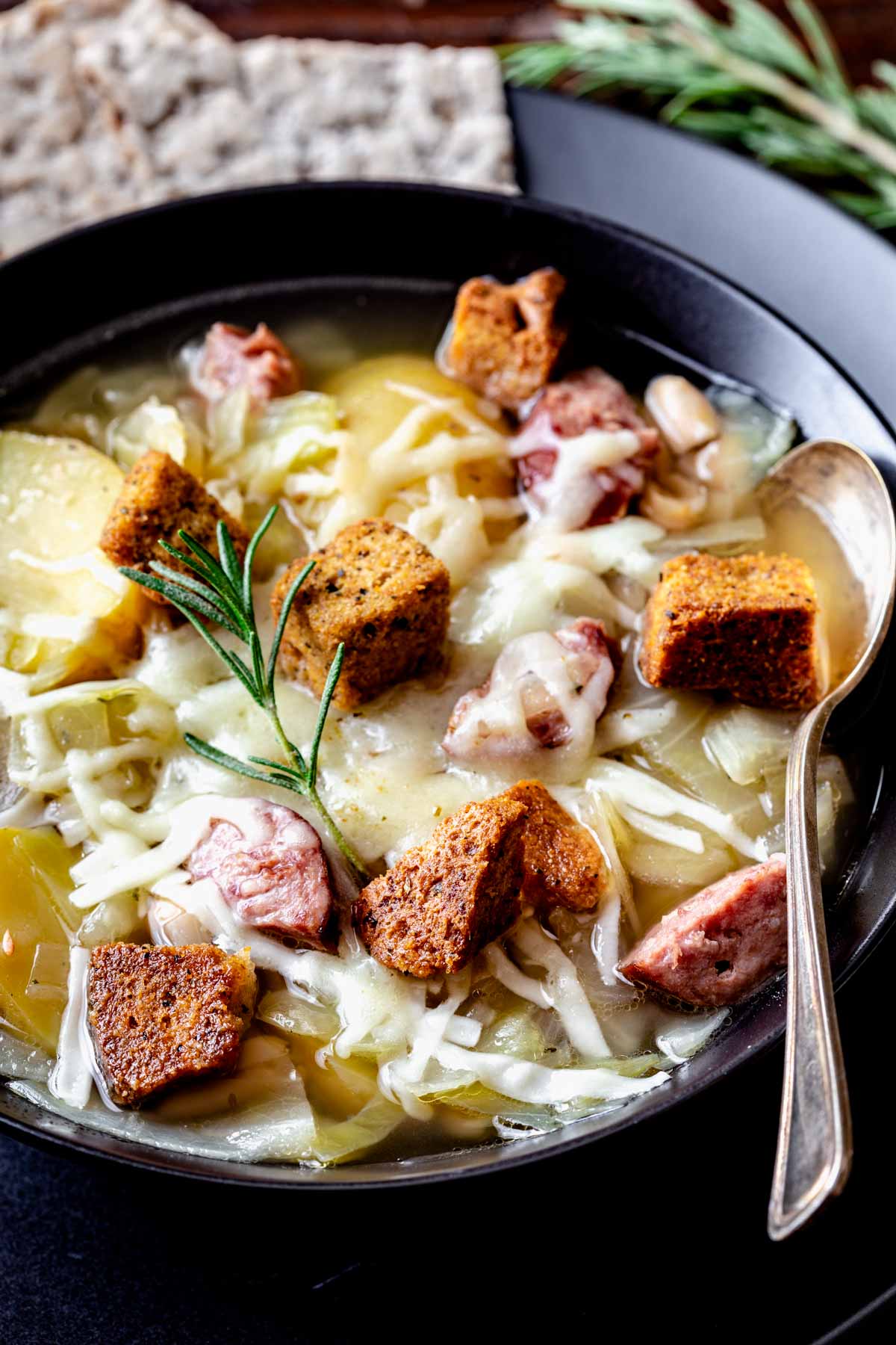kielbasa and cabbage soup in black bowl