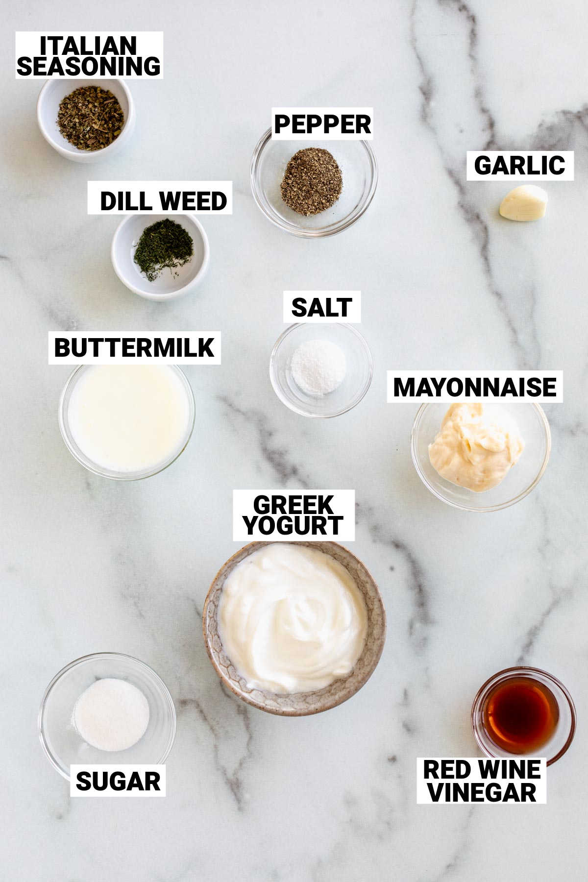 ingredients for italian salad dressing in small glass bowls on a work top