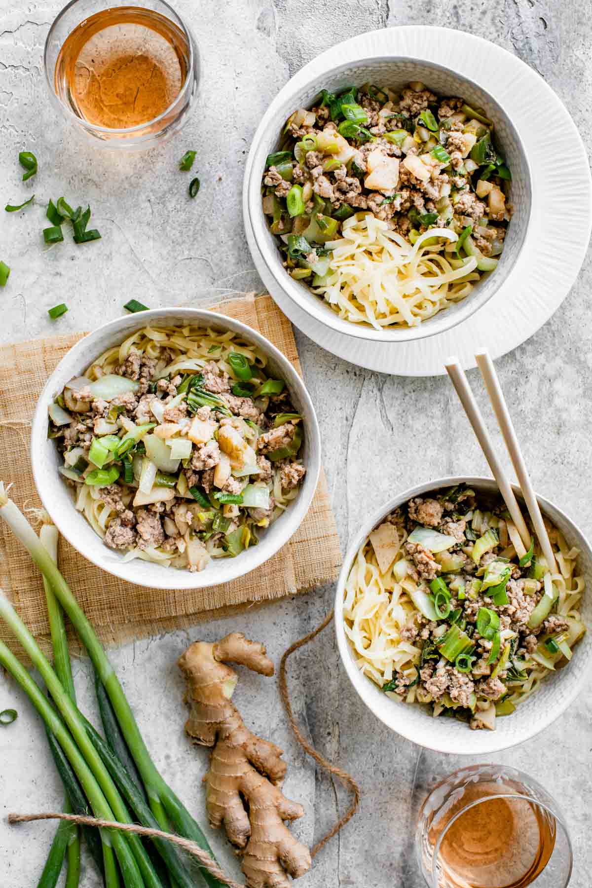 three bowls of stirfry over noodles