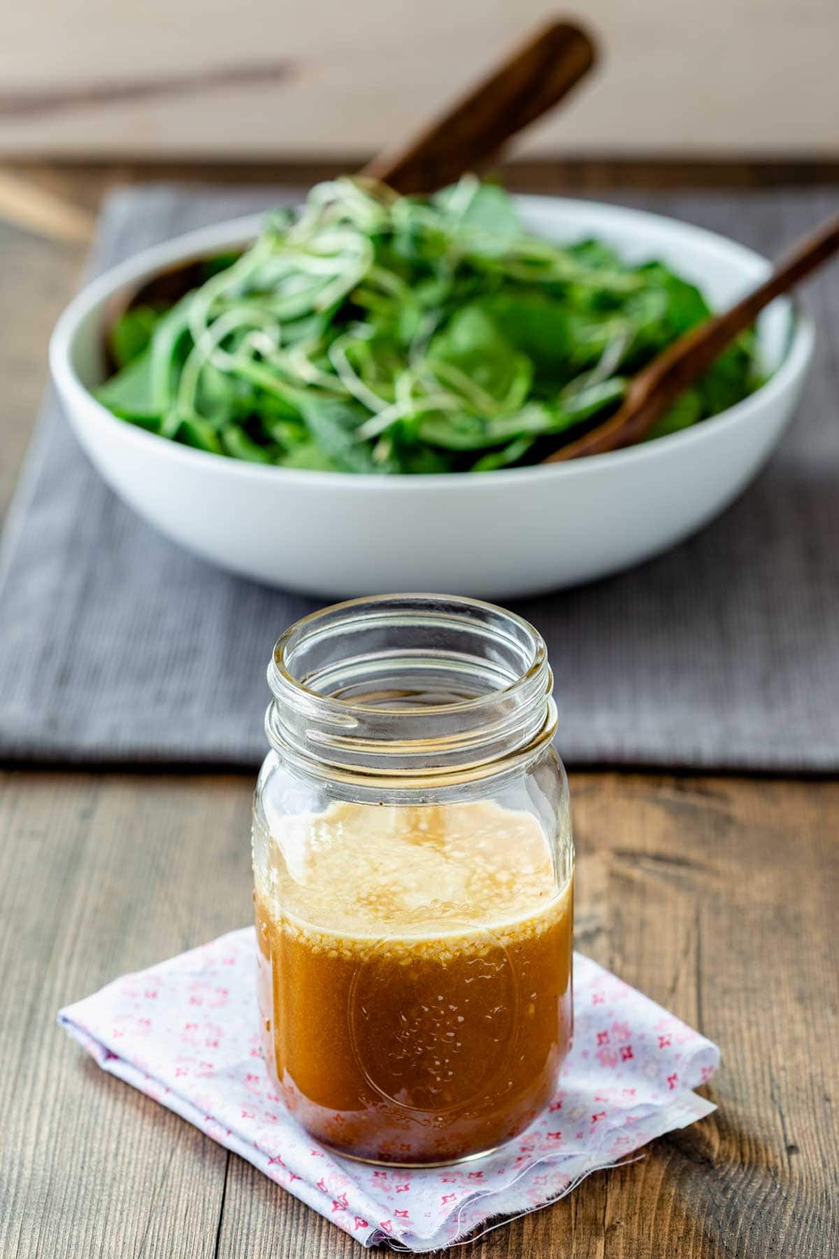 the dressing in front of a bowl of salad