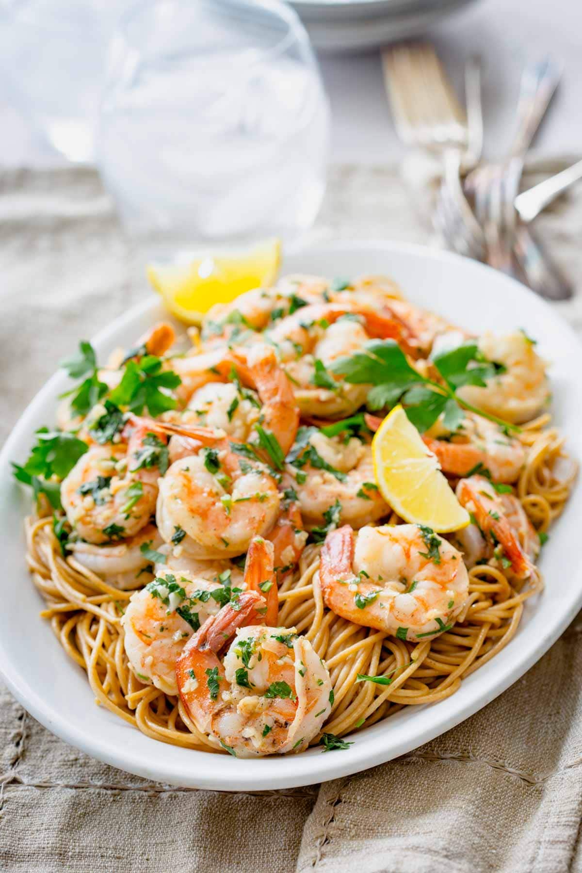 shrimp over pasta on a white platter