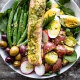 a close up overhead of salmon nicoise with pesto