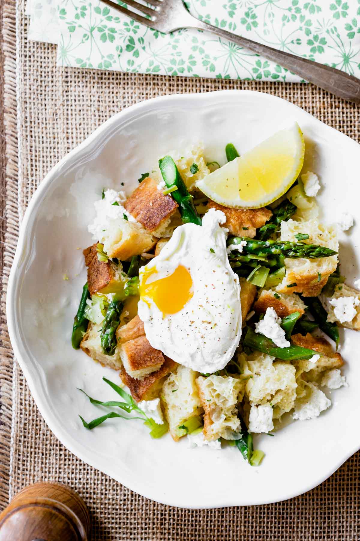 overhead of panzanella with a poached egg in a white bowl