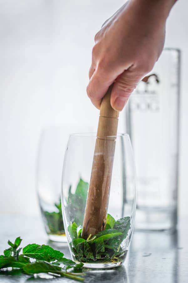 Fresh mint muddled with maple syrup in vodka spritzer cocktails