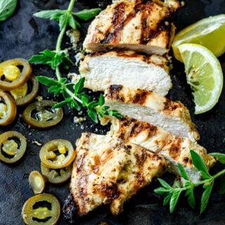 grilled chicken with pickled jalapenos, lemon wedges and oregano sprigs