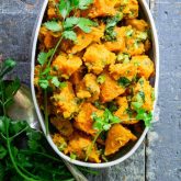 Paleo Sweet Potato Salad in a white dish on a blue surface