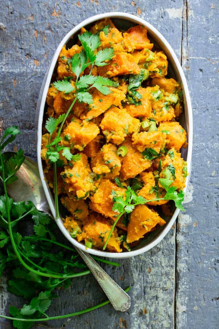 Paleo Sweet Potato Salad in a white dish on a blue surface