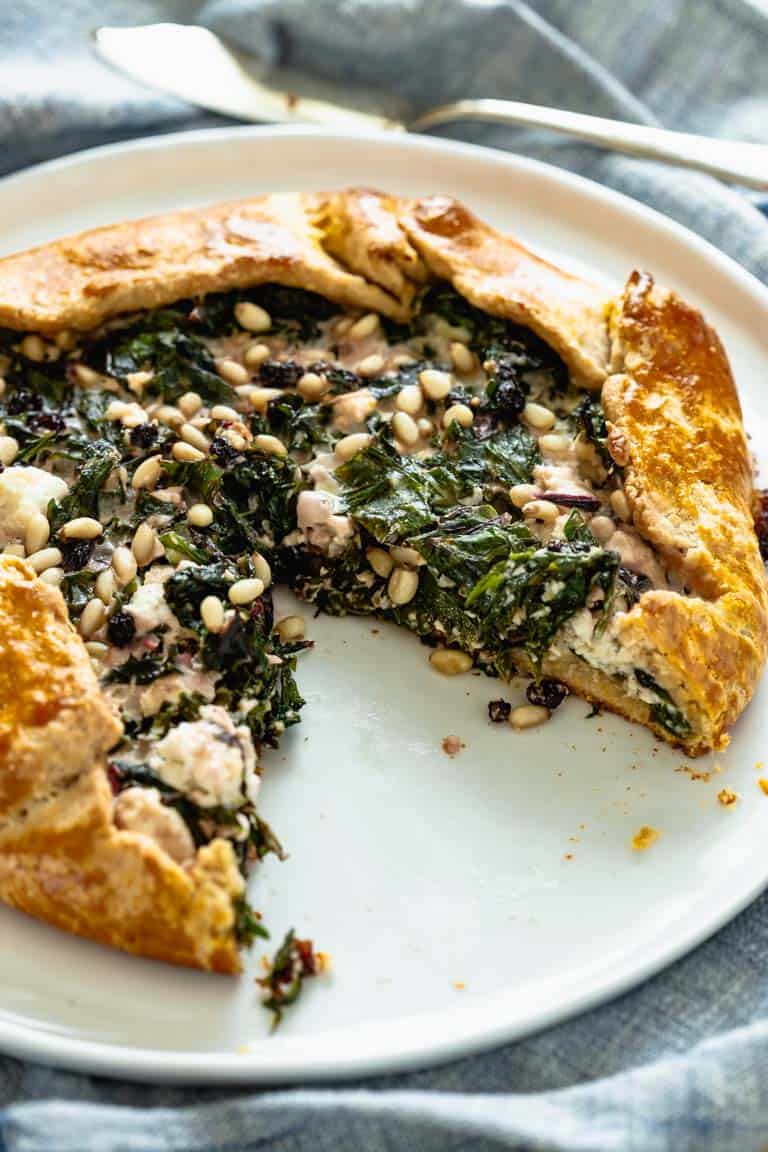 the savory galette on a platter with a slice removed