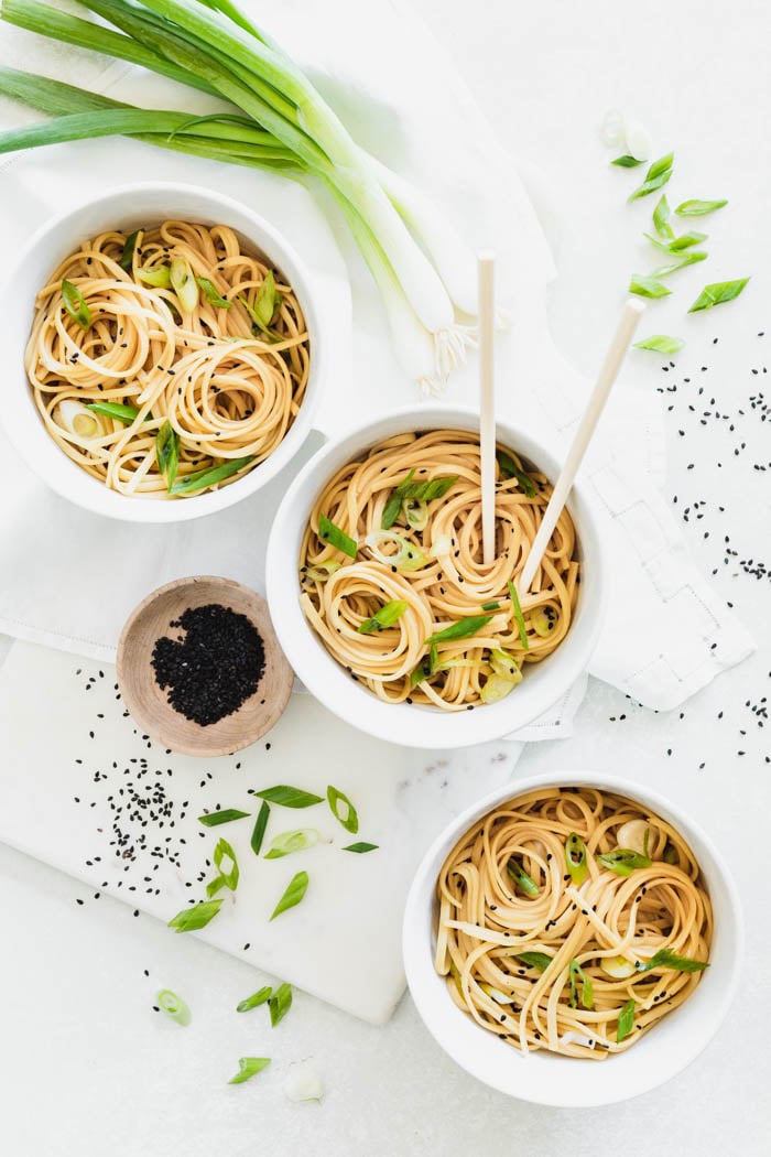 sesame noodles in a three bowls on a white table