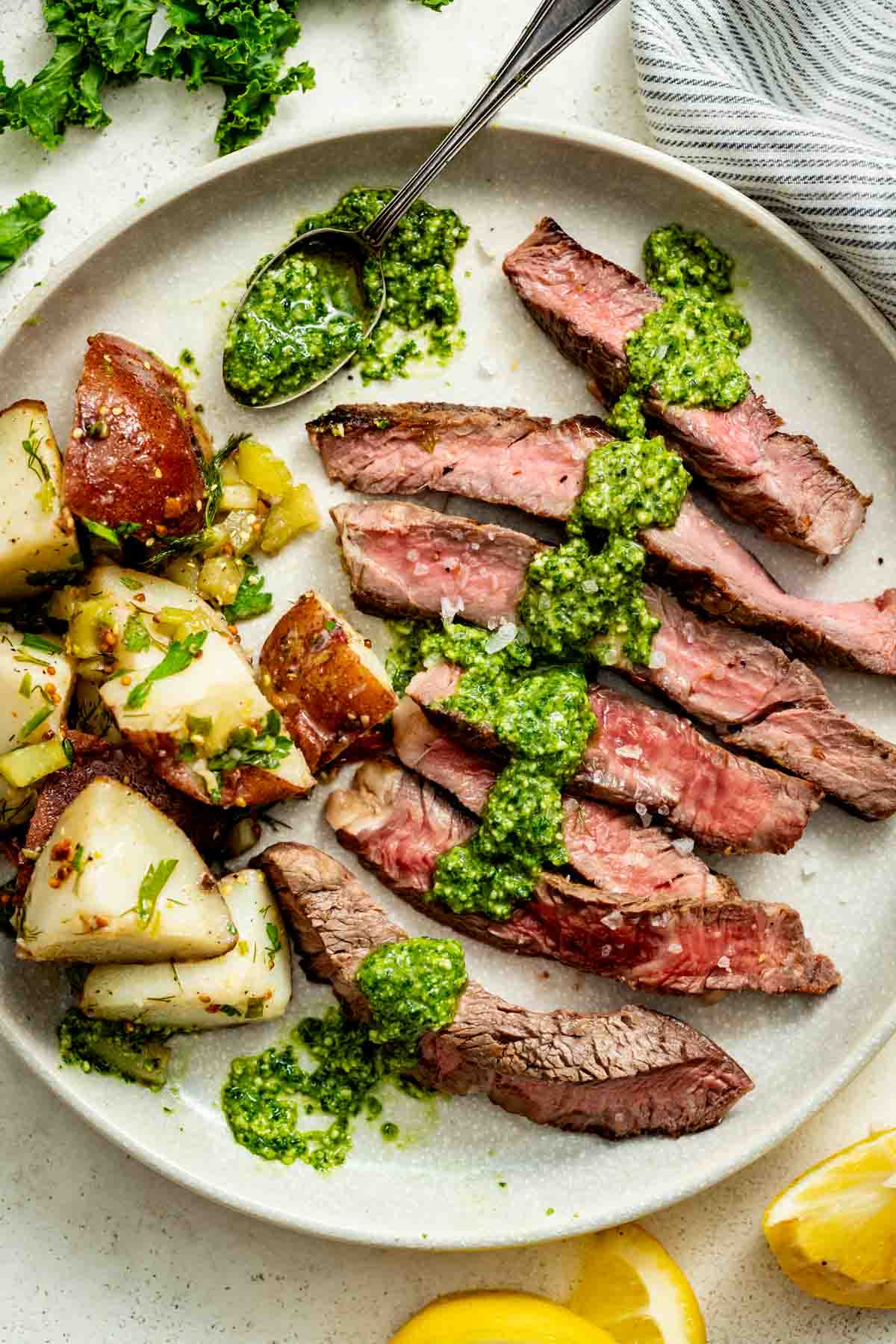 the sliced steak with the pesto on it on a plate with potato salad with herbs