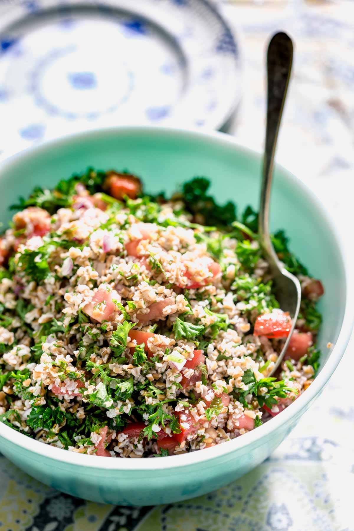a teal bowl with tabbouleh in it