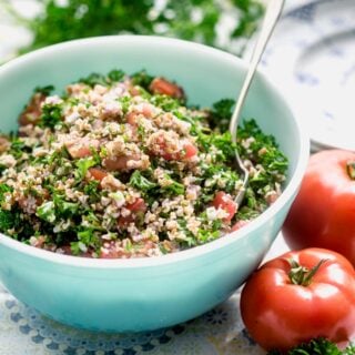 side view of a teal bowl with tabbouleh in it