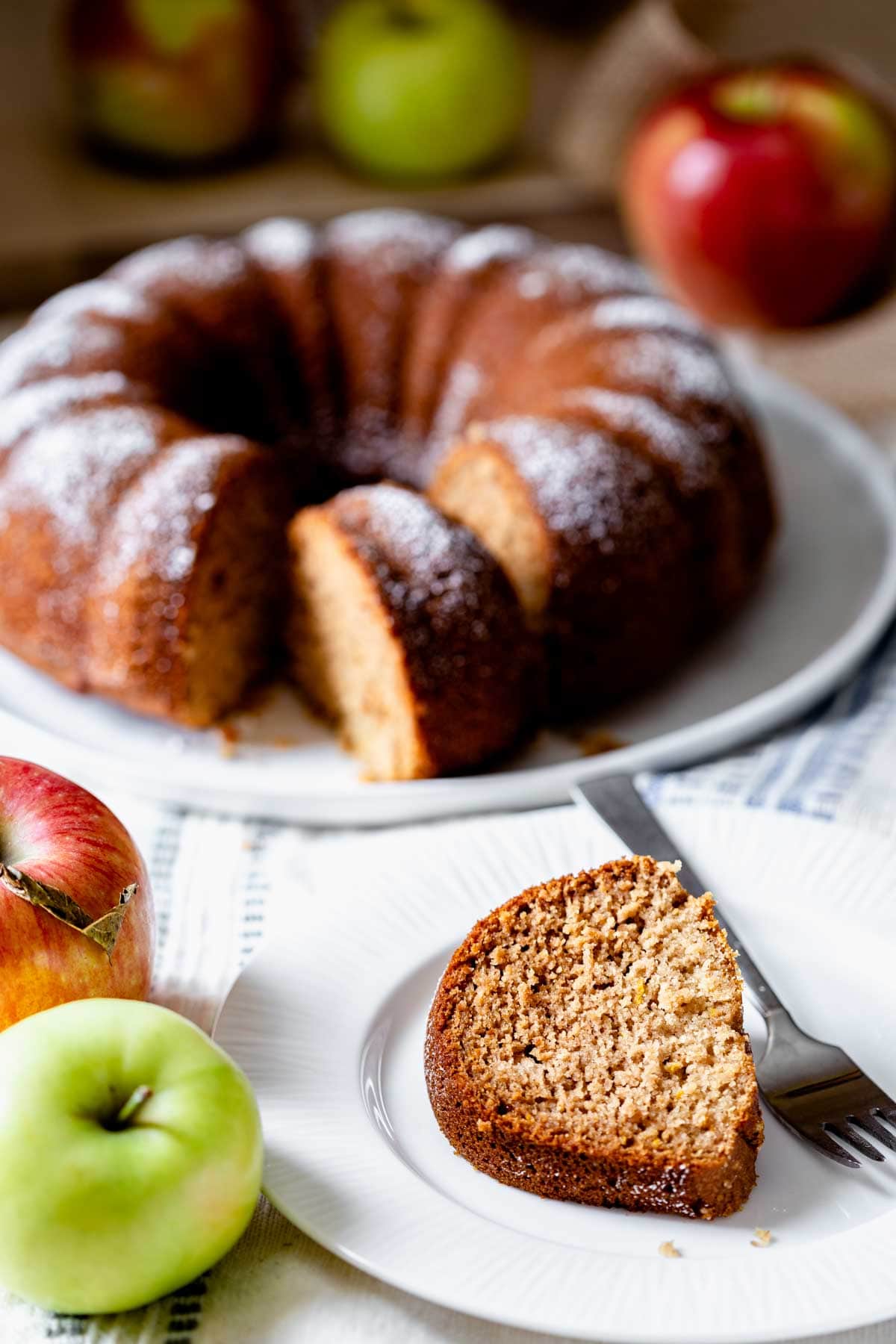 a slice of the cake in the foreground and the bundt in the background