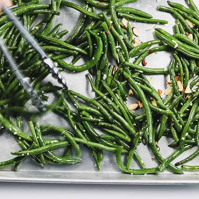 spreading the green beans on a sheet pan