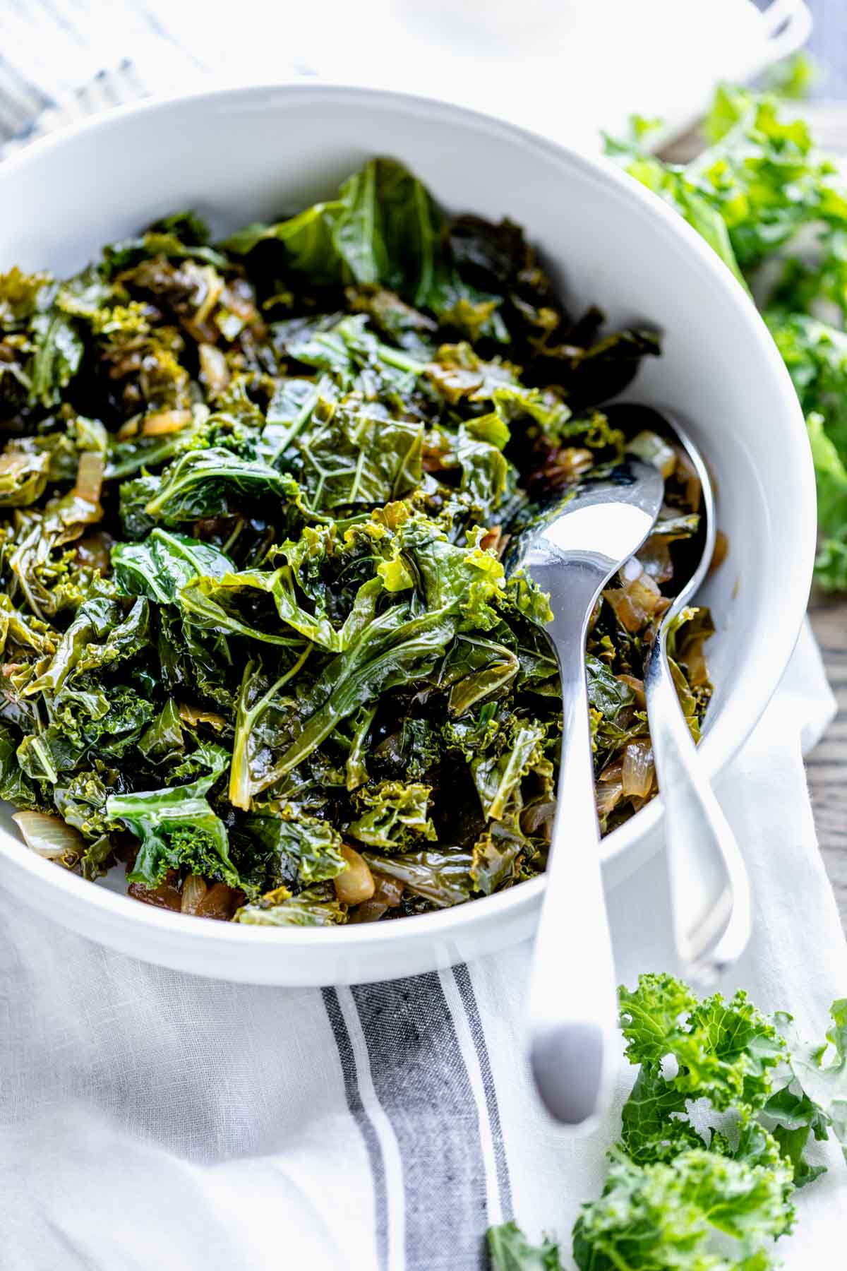 close up of sauteed kale in circular white serving dish