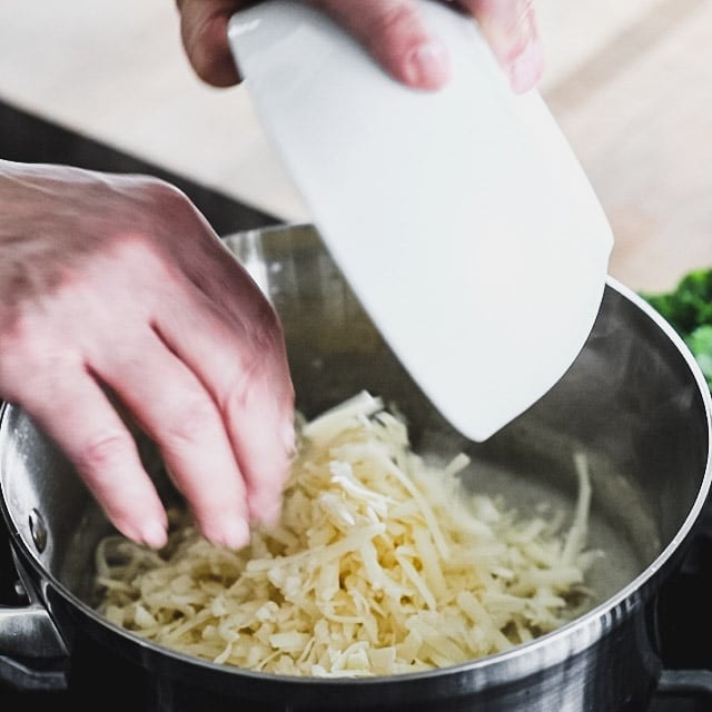 adding cheese to the sauce