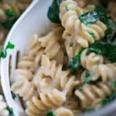 a pot of mac and cheese up close with kale in it