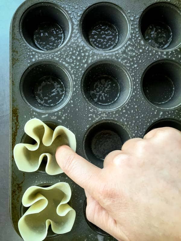 Pressing wonton wrappers into mini muffin tin