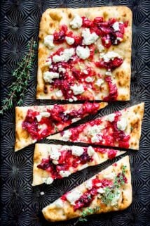 cut cranberry flatbread on a Black baking sheet
