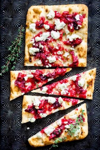 cut cranberry flatbread on a Black baking sheet