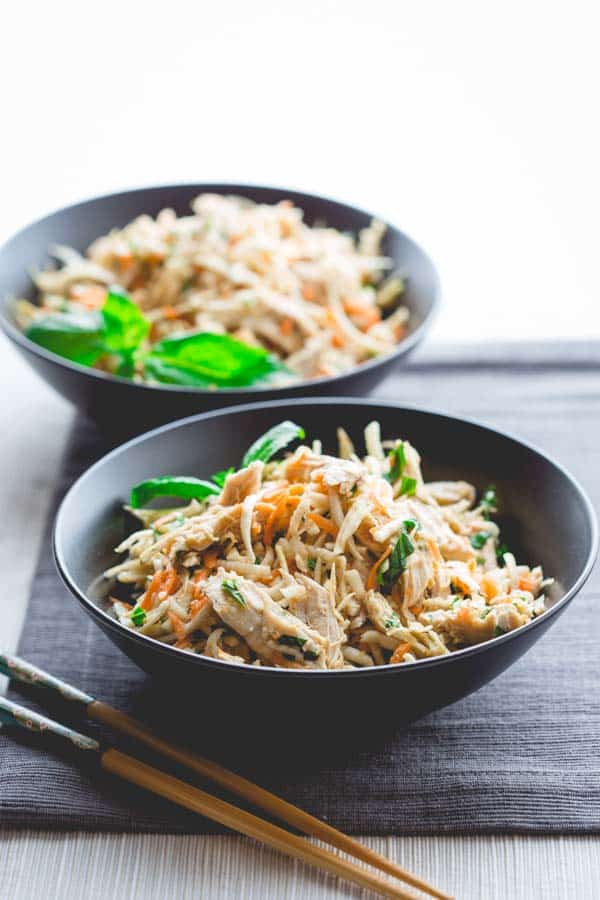 Sesame Ginger Chicken Celery Root Salad in two bowls with chop sticks beside them