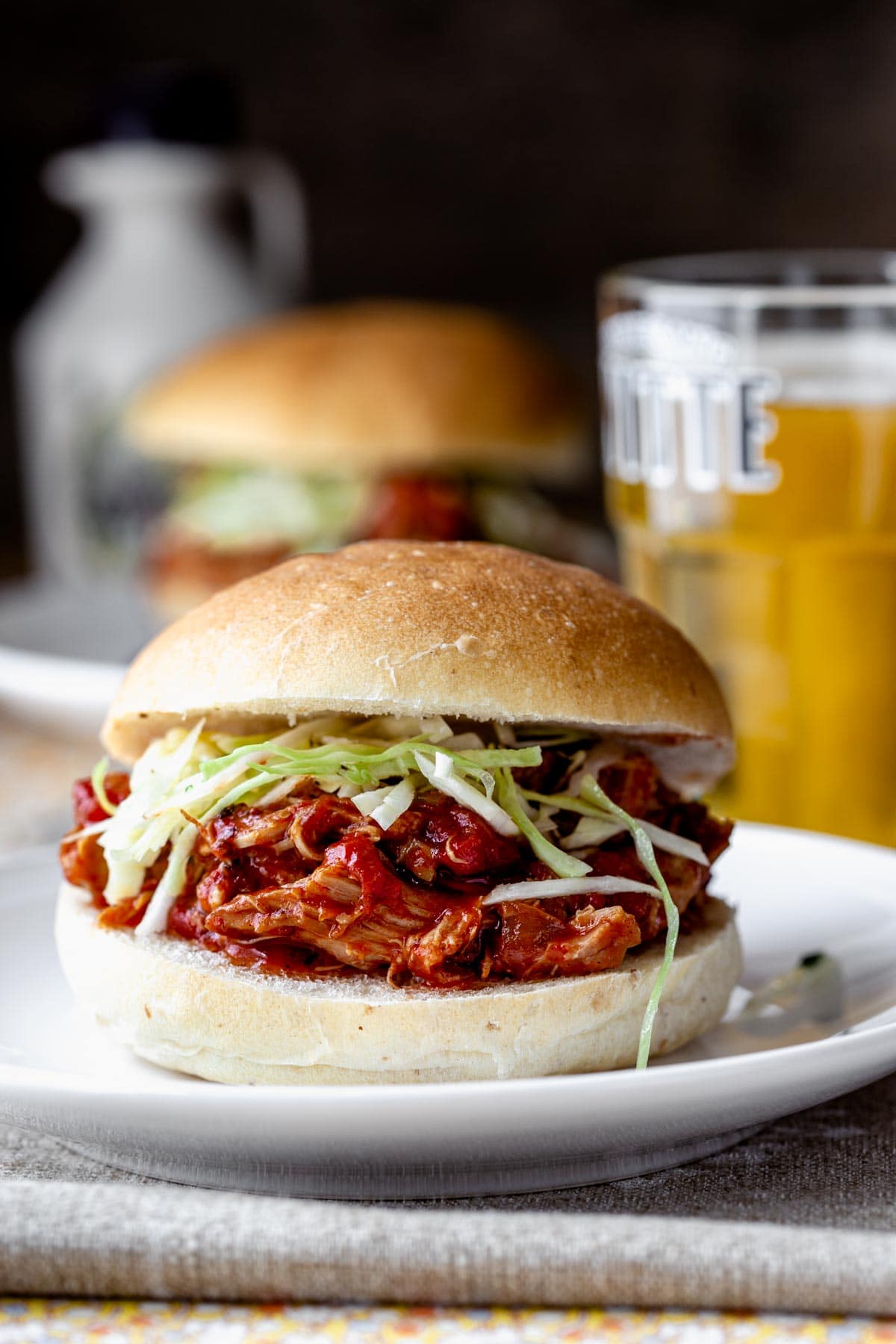 a side view of a very full sandwich dripping with barbecue sauce