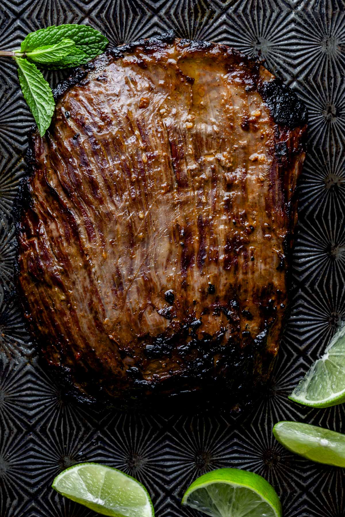 the steak resting on a black cookie sheet