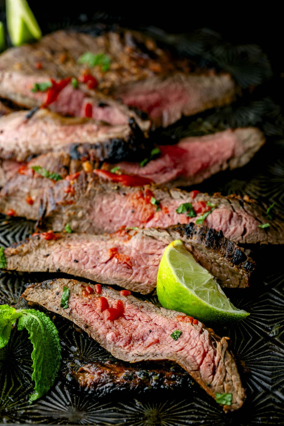 the steak sliced on a black cookie sheet
