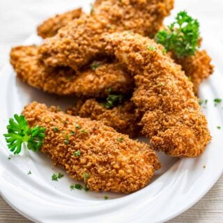 crispy tenders on a white plate with parsley