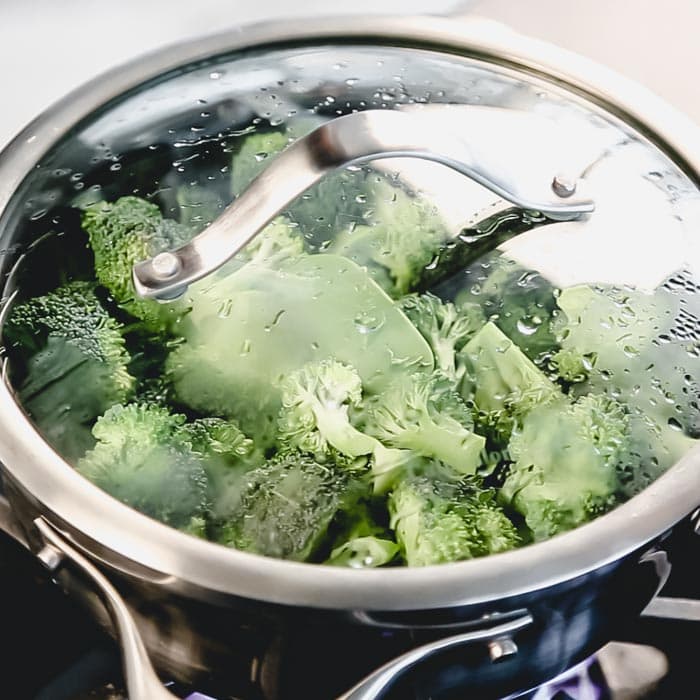 broccoli in a pot set up with a steamer basket