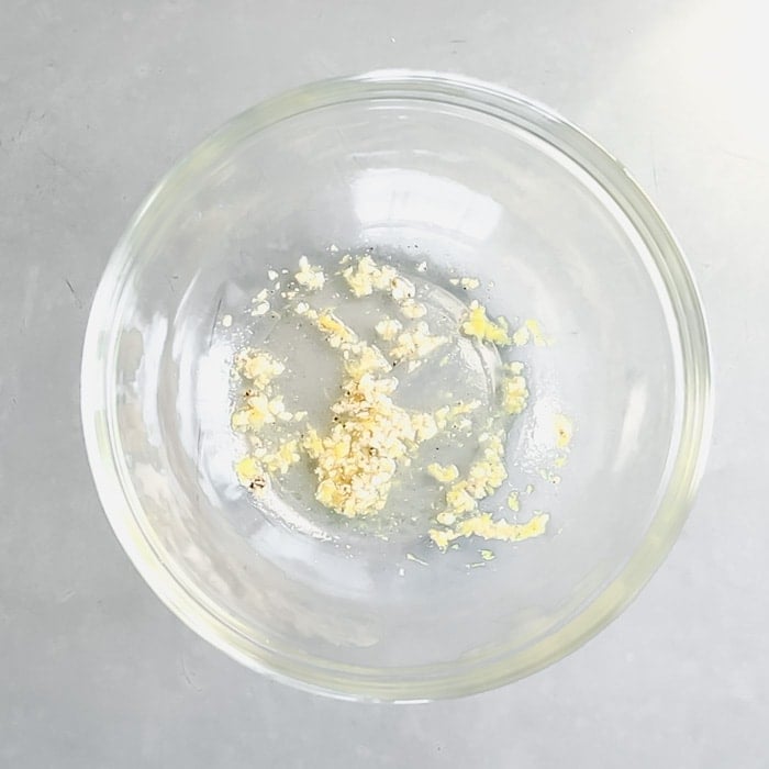 Scrape the garlic and oil into a bowl. Add the lemon juice, salt and pepper.