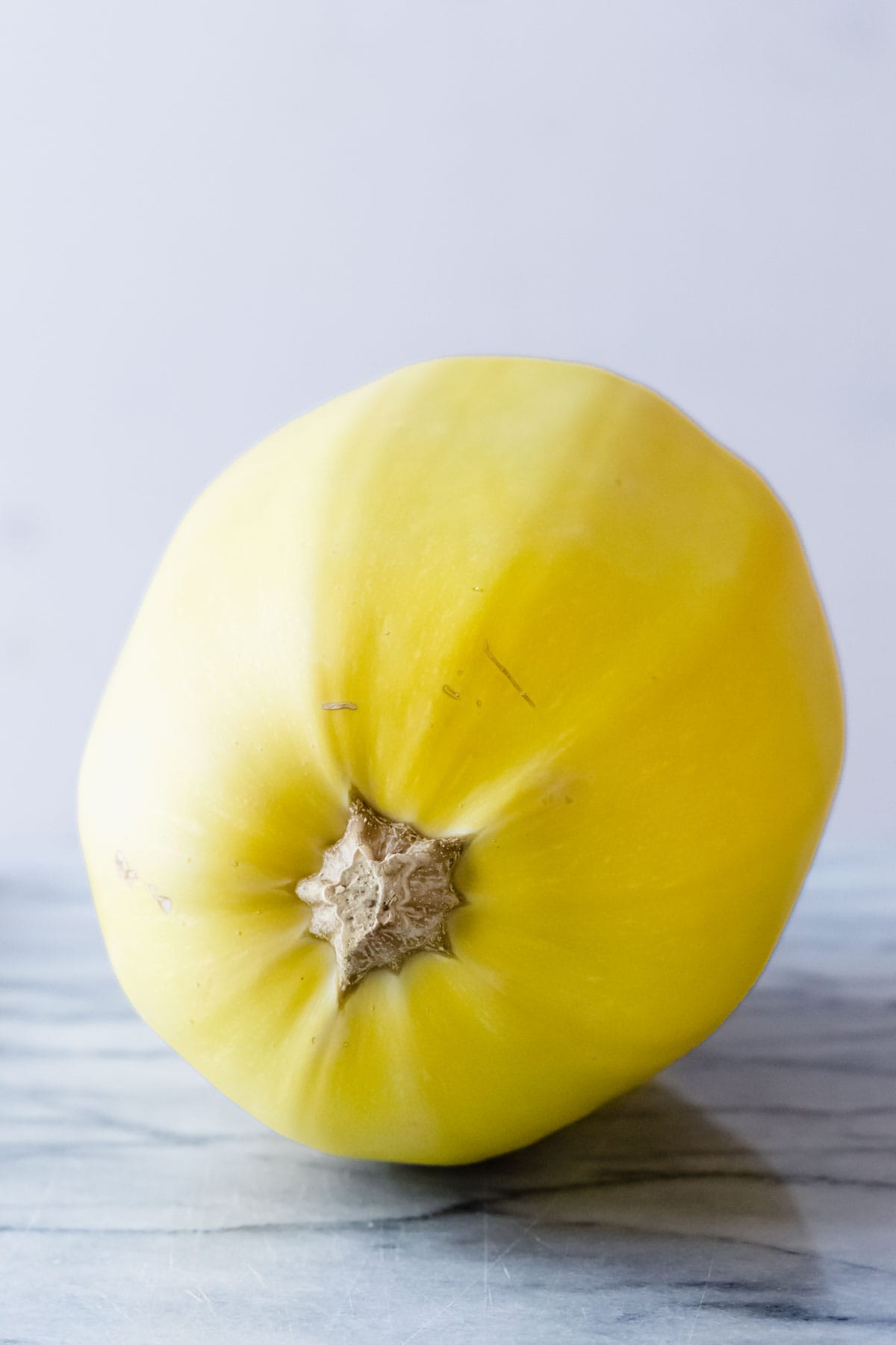 a whole spaghetti squash on a marble board