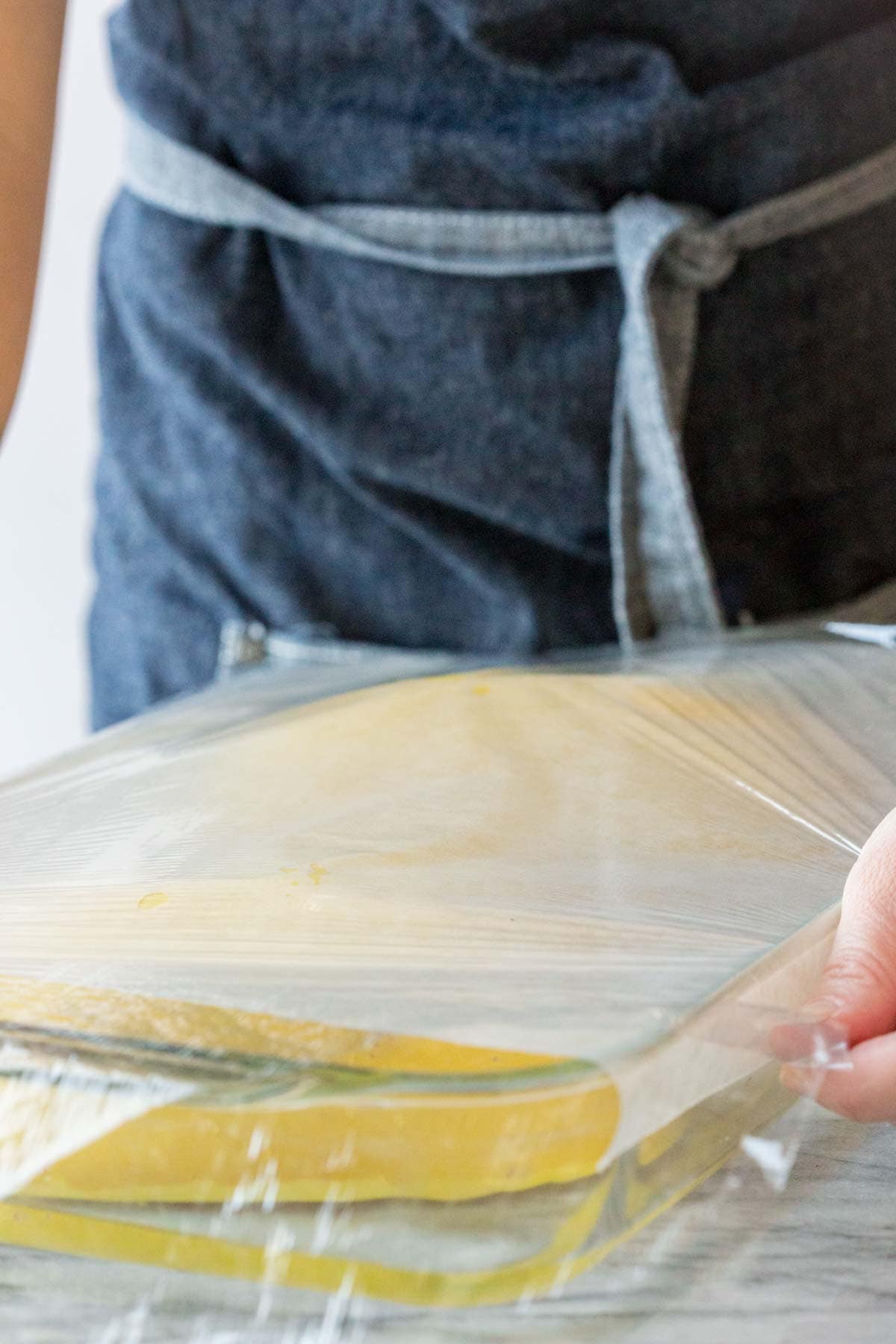 cover the spaghetti squash with parchment and plastic wrap