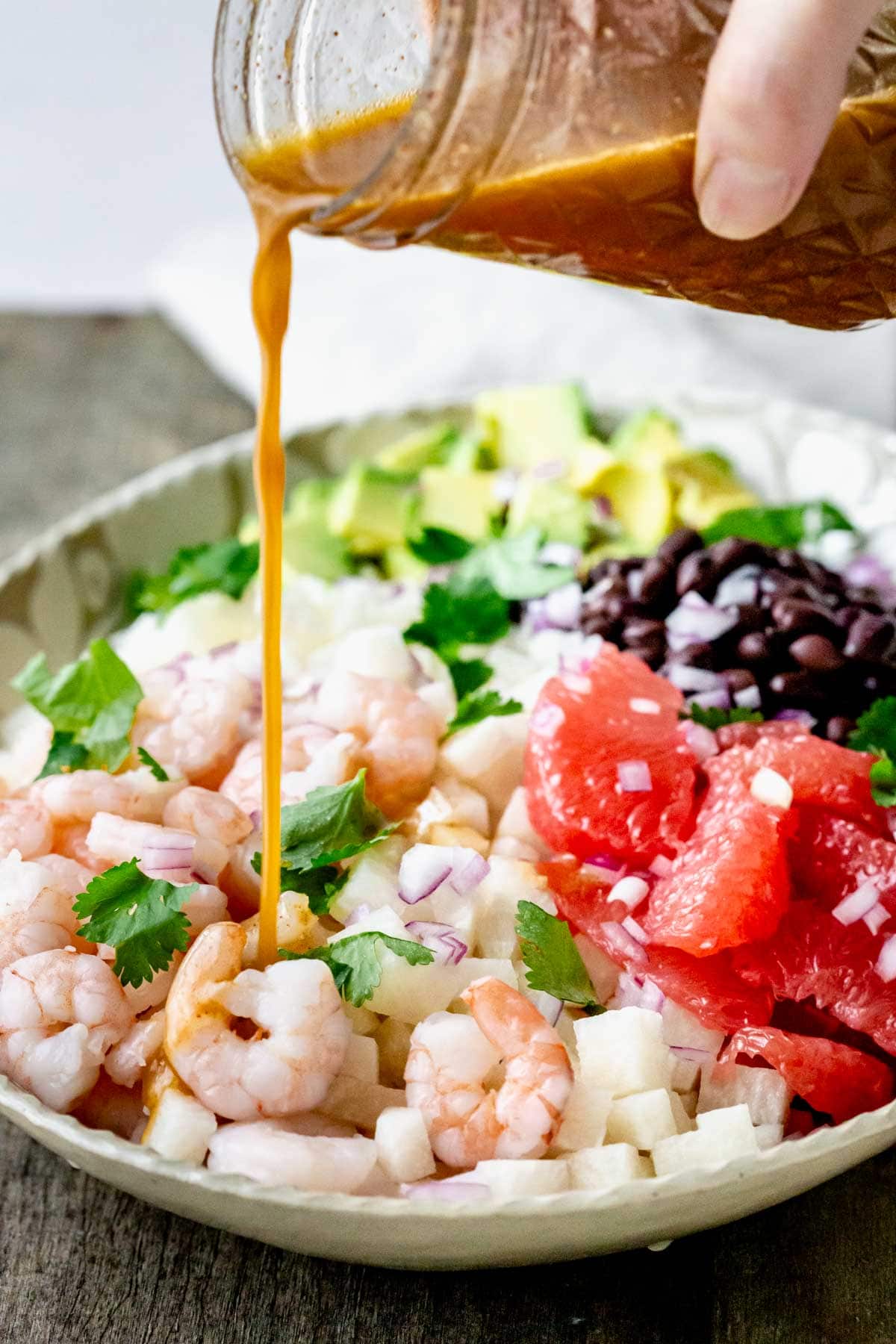 pouring dressing on the salad