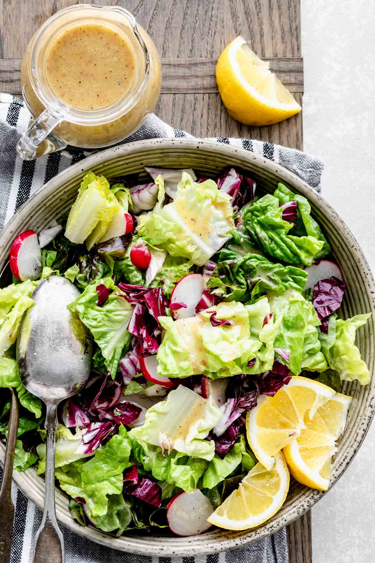 overhead of salad with a pitcher of dressing on a cutting board