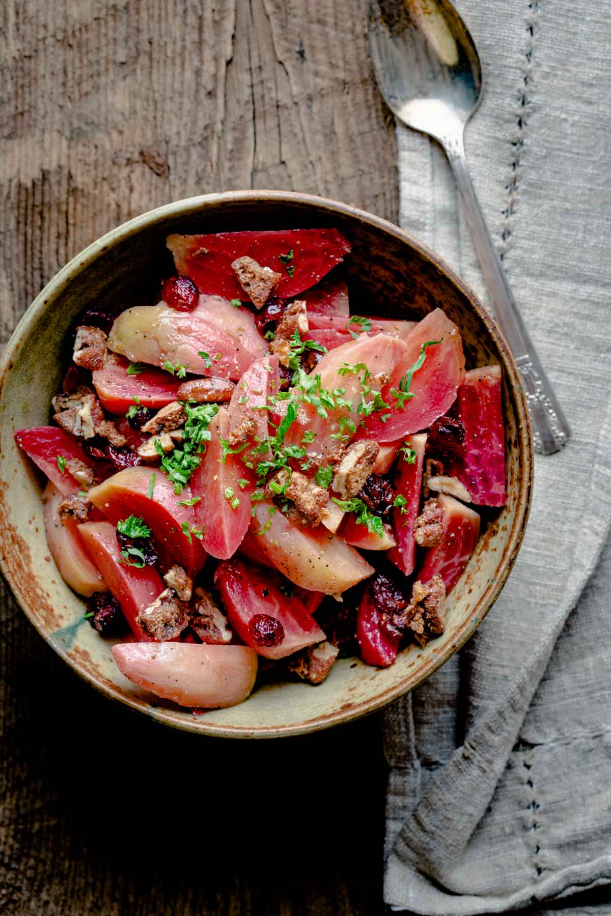 beets with spiced nuts in a ceramic bowl on a wooden tabletop