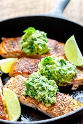 the salmon in the skillet with avocado mash on top of each serving
