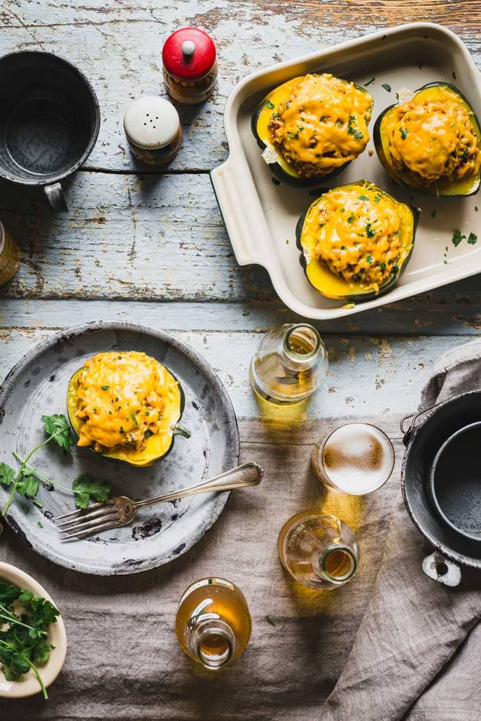 Stuffed acorn squash from overhead on a table with beer and cilantro