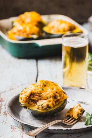 Stuffed Acorn Squash from the side on a plate with a forkfull removed.