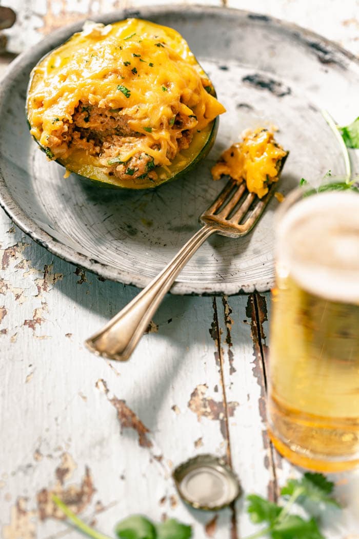 Stuffed Acorn Squash on a metal plate with a fork sitting on the plate