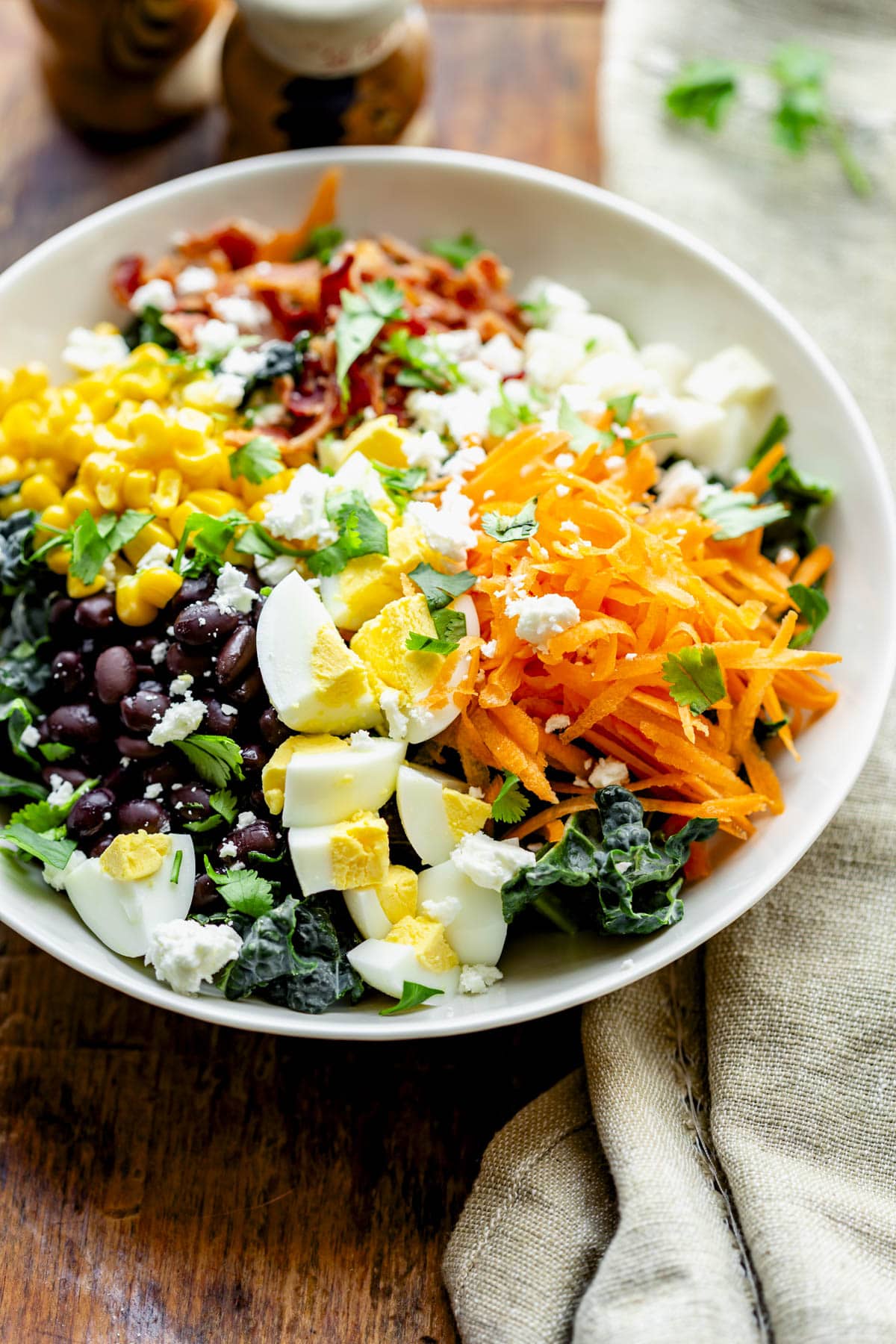 the cobb salad in a bowl with a tan linen napkin