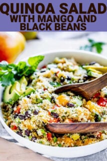 side view of the quinoa salad in a white view with wooden salad tongs with text overlay