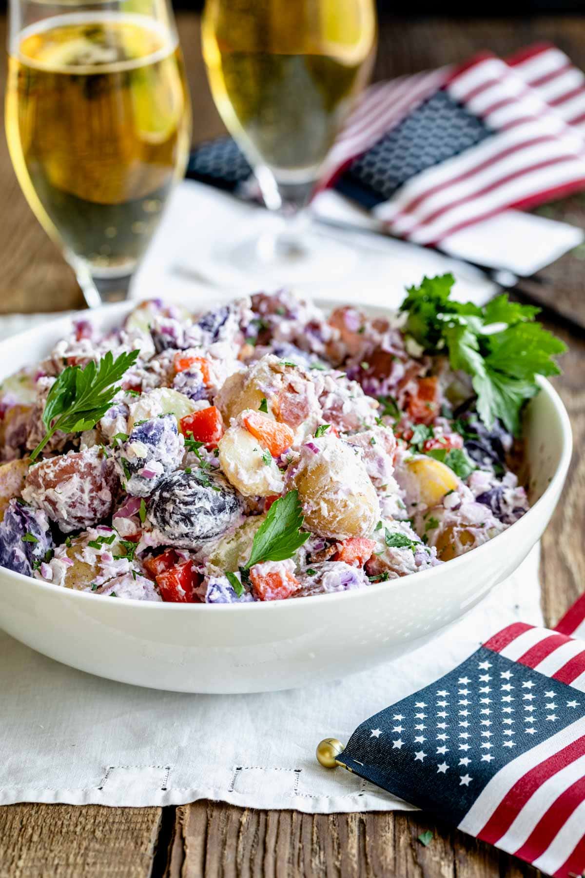 side view of the bowl of potato salad on a table with flags and beer