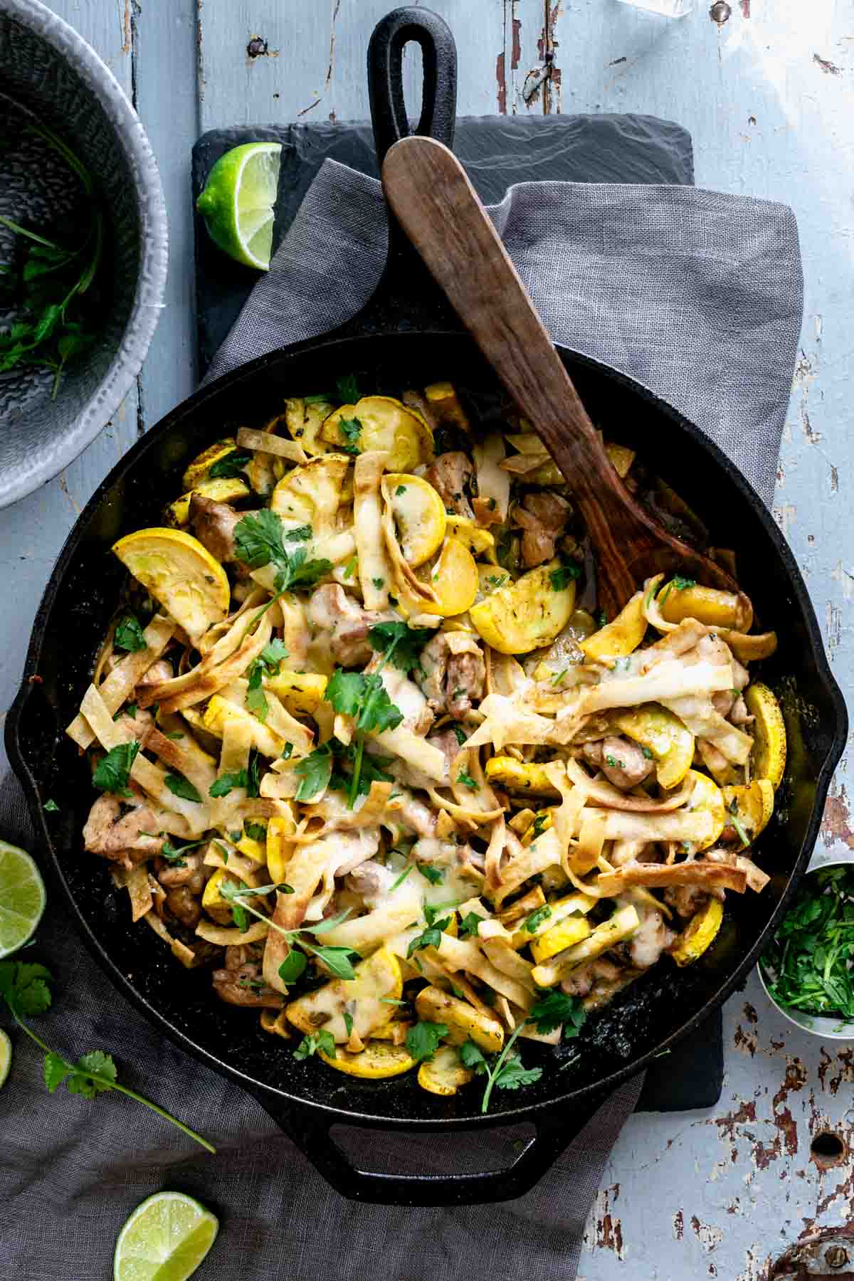 black cast iron skillet with chicken and yellow squash