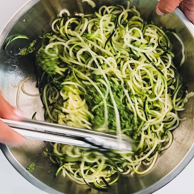 tossing pesto with zoodles