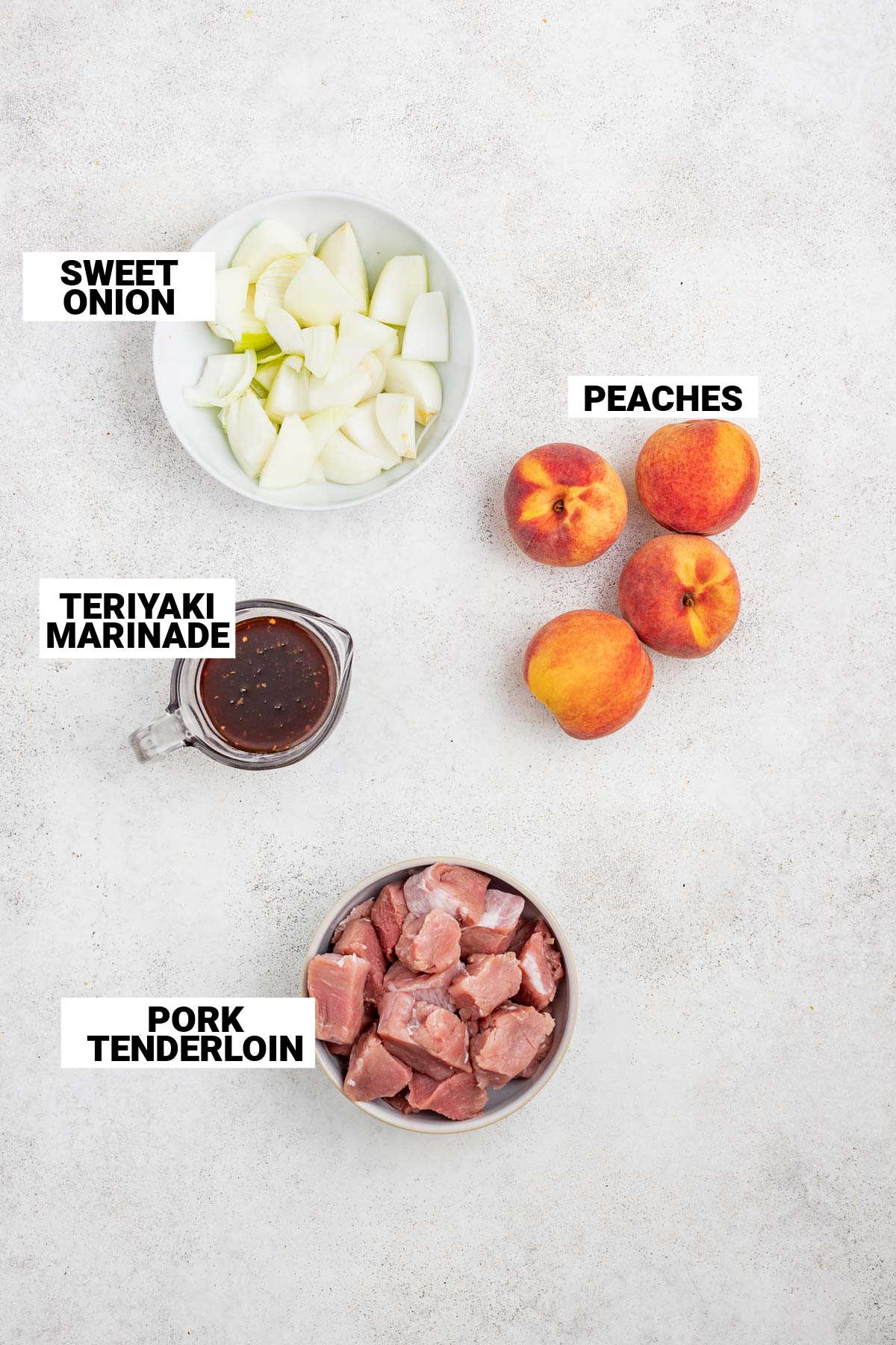 the ingredients (pork, peach, onion and marinade) on a white table