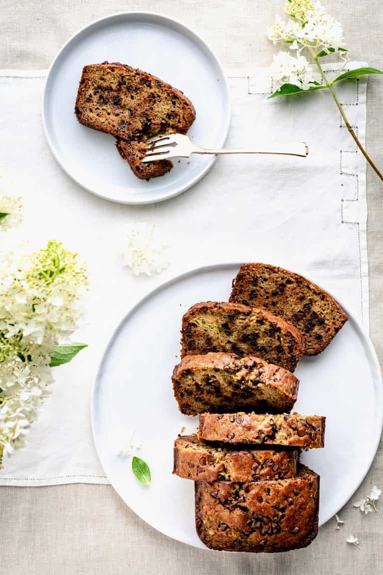Chocolate Chip Zucchini Bread slice on a plate and sliced loaf