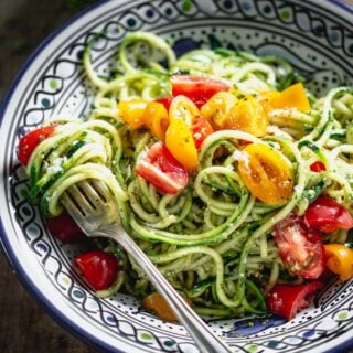 zucchini noodles with pesto in a blue bowl