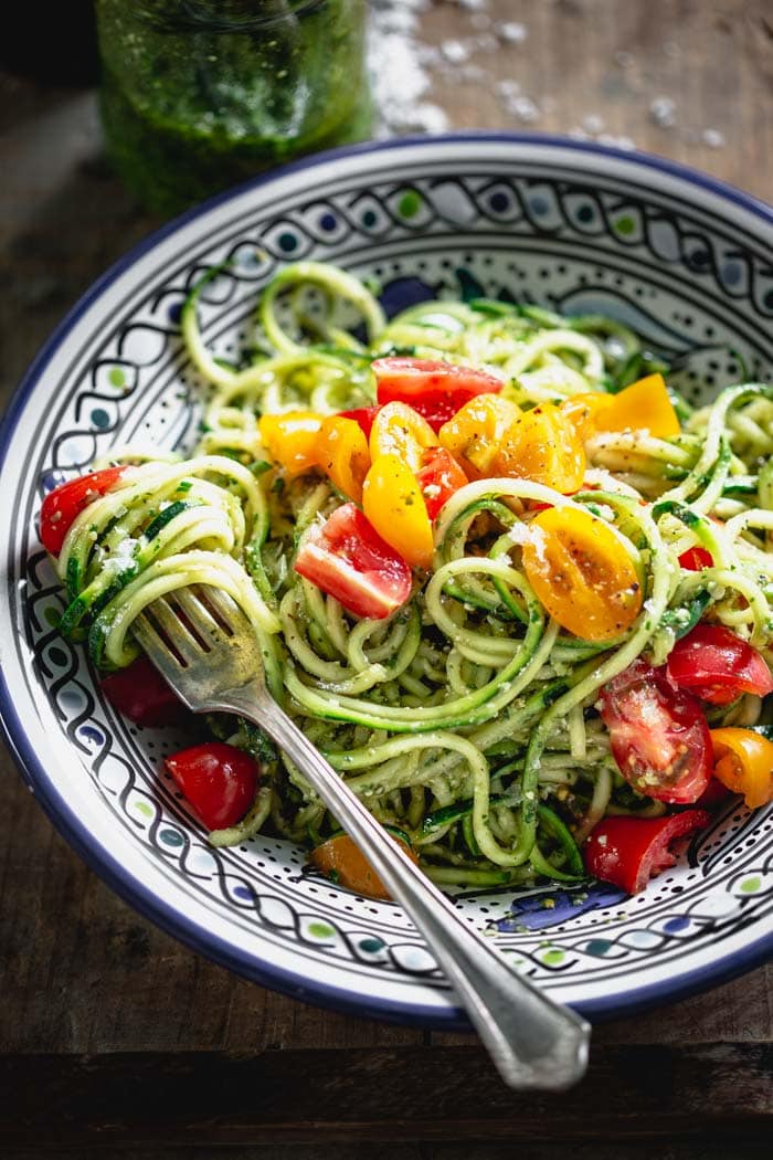 zucchini noodles with pesto in a blue bowl