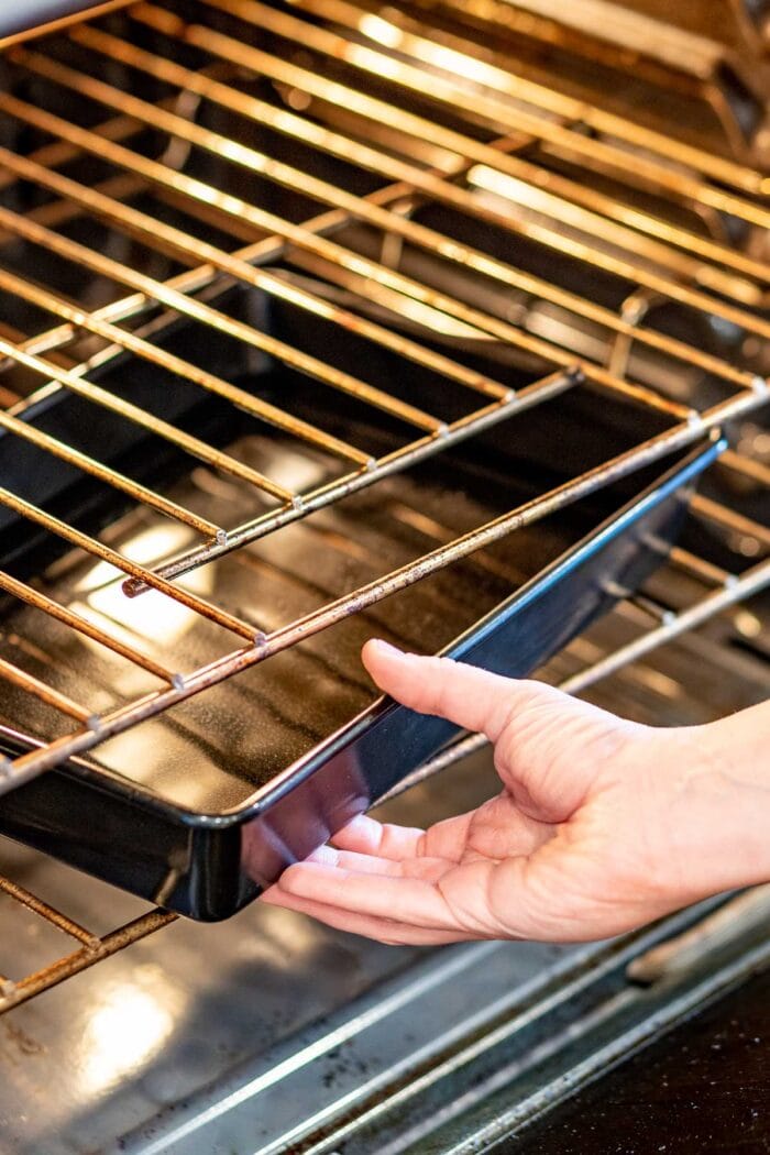 setting a pan of water in the oven to help the cake rise evenly and not brown too much on the bottom